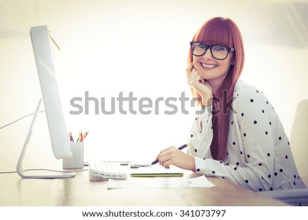 Attractive hipster woman using graphics tablet in her office