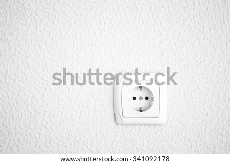 Light plastered wall with electric outlet for background. Close up detale. Toned.