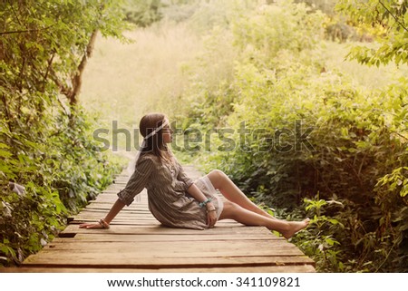 beautiful girl on old wooden brdge in forest