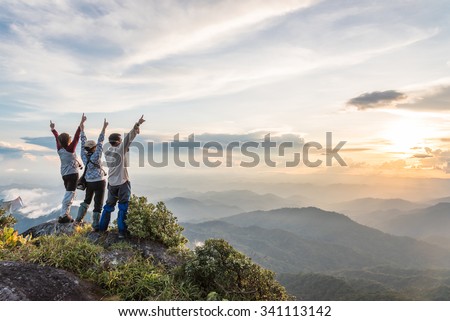 Young happy tourist on top of a mountain enjoying valley view before sunset. Royalty-Free Stock Photo #341113142