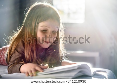 Cute Girl Reading at Home Royalty-Free Stock Photo #341210930