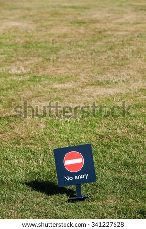 Color image of a 'No Entry' sign on a meadow.