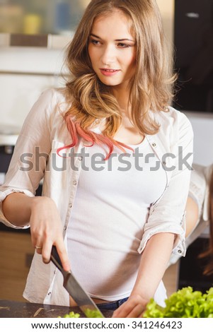 Pretty blonde woman preparing food in a kitchen