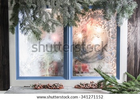 Christmas colorful blur. Christmas tree ornaments and boxes with presents as seen through window with ice