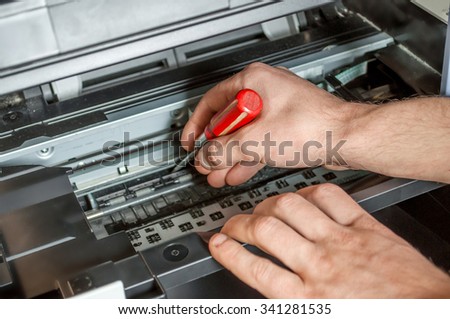 Maintenance and repair the printer screwdriver and hands Royalty-Free Stock Photo #341281535