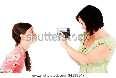 Woman filming a girl with a home video camera isolated over white