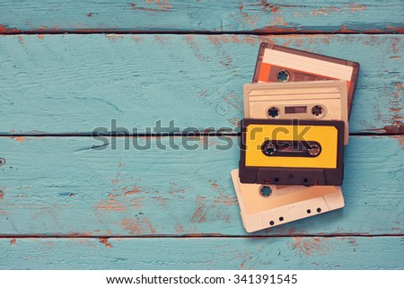 Cassette tapes over blue textured wooden table . top view. retro filter

