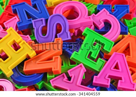 Heap of plastic colored alphabet letters close up 
