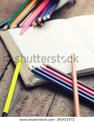 Colored pencils with blank sketch book on wooden background,education concept -vintage effect.