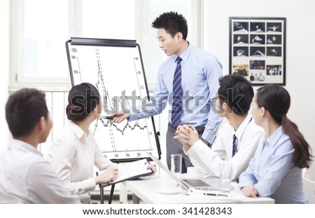 Businessman pointing at graph during presentation in boardroom