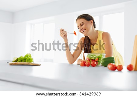 Healthy Diet. Beautiful Smiling Woman Eating Fresh Organic Vegetarian Salad In Modern Kitchen. Healthy Eating, Food And Lifestyle Concept. Health, Beauty, Dieting Concept.