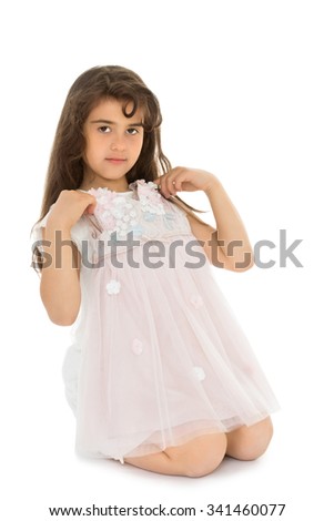 Funny little dark-haired girl tries on a dress-Isolated on white background