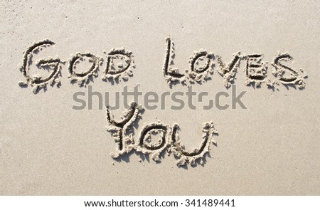 "God loves You" writtwen on sand beach
