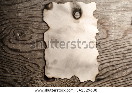 burnt paper sheet on a wooden background,horizontal photo
