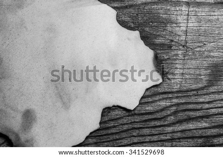 burnt paper sheet on a wooden background,black and white,horizontal photo
