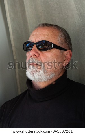 mature man with sunglasses dressed in black 
