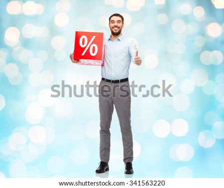 people, sale, shopping, discount and christmas concept - smiling man holding red percentage sign over blue holidays lights background