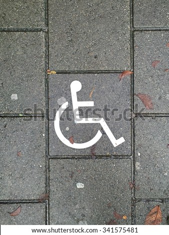 Disability or wheel chair symbol on the brick floor