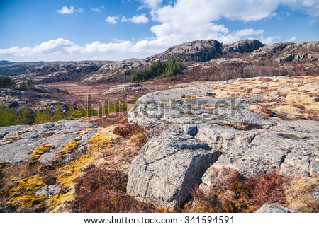 Spring Norwegian mountain landscape with rocks under cloudy sky