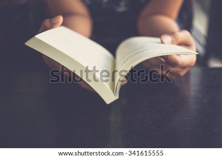 Woman place her arms on her lap and open book to read Royalty-Free Stock Photo #341615555