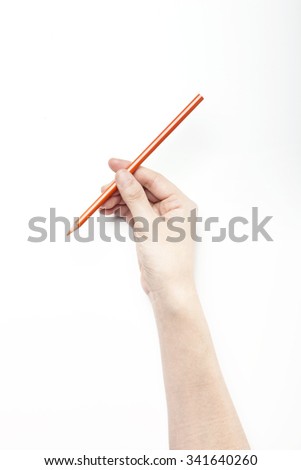 A woman hand hold a orange pencil on the white desk(table, board) top view isolated white at the studio.