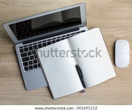 Laptop and Notepad with pen - top view on wooden table with space for your text.
