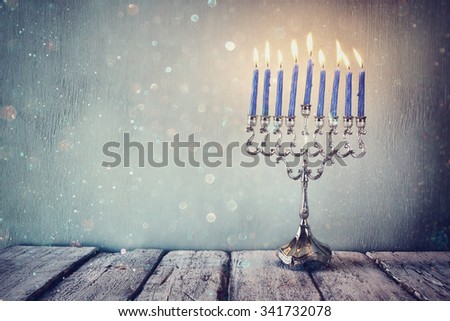 low key and vintage filtered image of jewish holiday Hanukkah with menorah (traditional Candelabra). glitter overlay