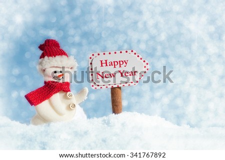 Snowman with Signpost, Happy New Year, against a blue sky with snowflakes
