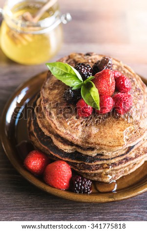Homemade buckwheat pancakes with berry fruits in the plate,selective focus 