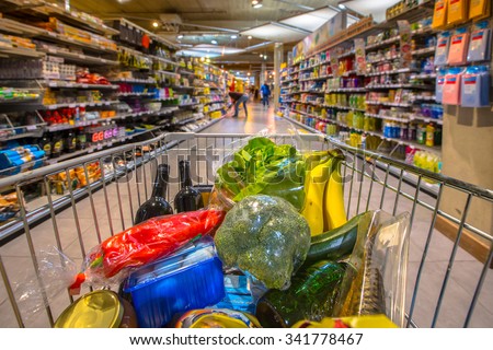 Grocery cart at a supermarket aisle filled up with food products seen from the customers point of view Royalty-Free Stock Photo #341778467