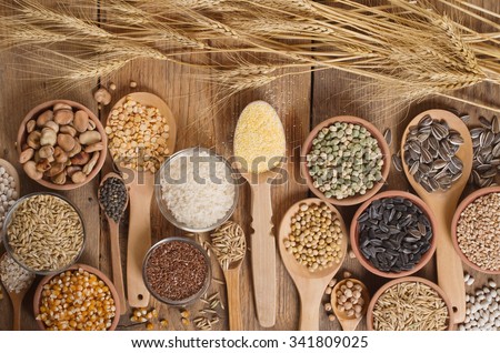 Cereal grains , seeds, beans on wooden background. Royalty-Free Stock Photo #341809025