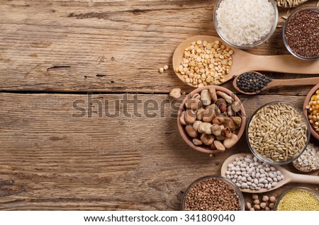 Cereal grains , seeds, beans on wooden background. Royalty-Free Stock Photo #341809040