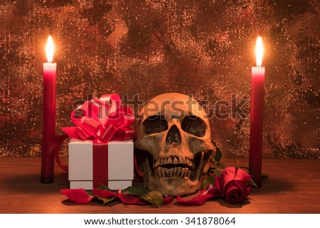 Still life painting photography with human skull, present, rose and candle on wooden table