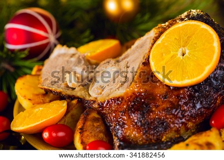Christmas roast duck served with potatoes, orange and tomatoes closeup