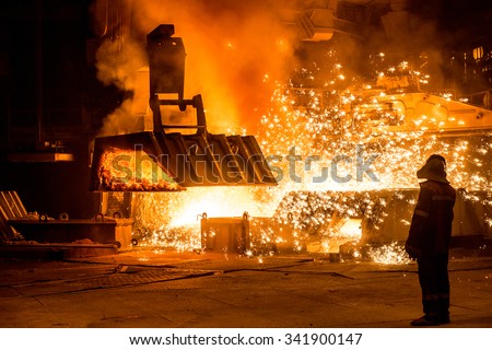 Steelworker near a blast furnace with sparks Royalty-Free Stock Photo #341900147