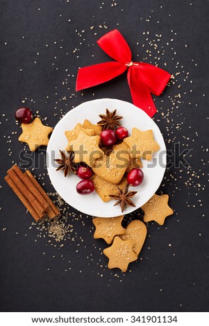 Homemade Christmas gingerbread cookies with festive decoration on dark background, top view