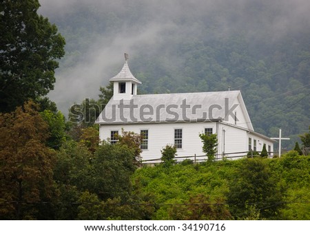 Tuckasegee Wesleyan church stands in the morning mist up on a hill in the Carolina mountains Royalty-Free Stock Photo #34190716