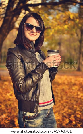 hipster girl holding cup of coffee in hand. Vintage photo