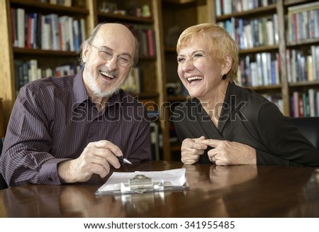 Elderly couple signing documents