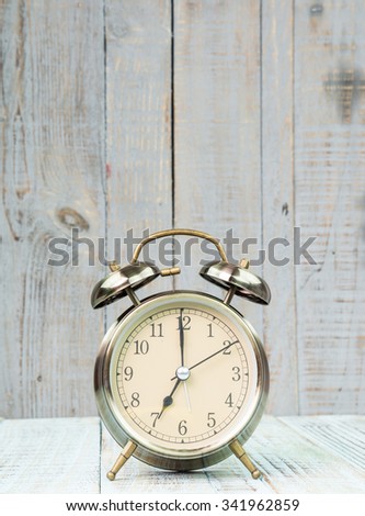 Vintage background with retro alarm clock on table
