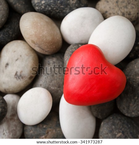 Red heart on pebble stones