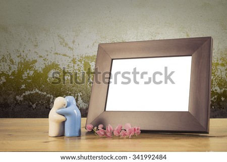 Still life with flowers and white photo frame on wooden table over grunge background. Valentine concept