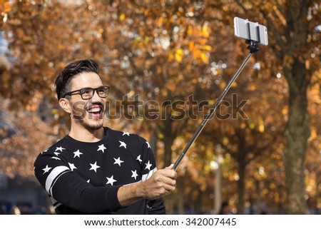 Young hipster taking a picture with a selfie stick