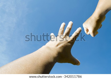 Hand fist into blue sky, rock scissor paper