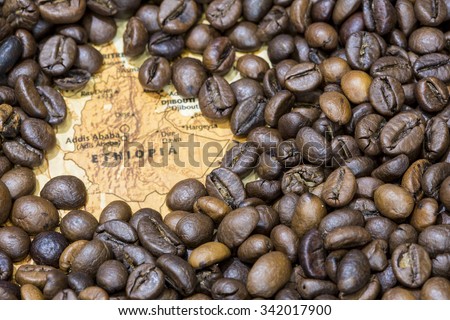 Vintage map of Ethiopia covered by a background of roasted coffee beans. This nation is between the five main producers and exporters of coffee. Horizontal image. Royalty-Free Stock Photo #342017900