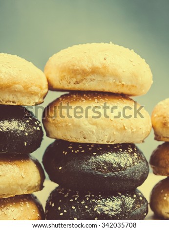 Stacked sandwich or burger bun with sesame seeds. Classic buns and colored with squid ink. Toned picture