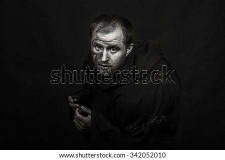 Beautiful and fascinating game theater actor on camera. Black and white photo of the actor in the guise of a beggar on a dark background. Beautifully decorated stage image and professional makeup. 