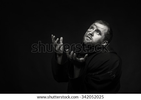 Beautiful and fascinating game theater actor on camera. Black and white photo of the actor in the guise of a beggar on a dark background. Beautifully decorated stage image and professional makeup. 