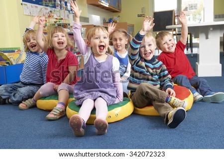 Group Of Pre School Children Answering Question In Classroom Royalty-Free Stock Photo #342072323