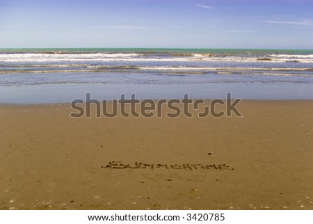 Summertime written on the sand as a meaning of summer and vacation